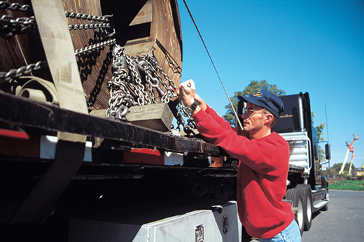 Experienced Buchanan flatbed truck driver preparing an open deck load for transport.