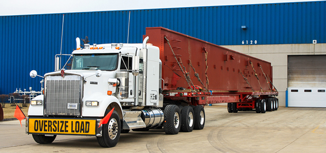 CDL-A heavy haul driver transporting an oversize load on a specialized trailer