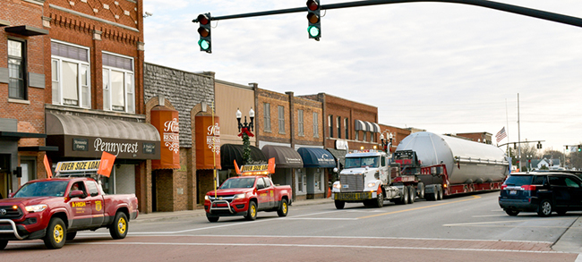 Specialized freight transport moving heavy equipment with professional driver support